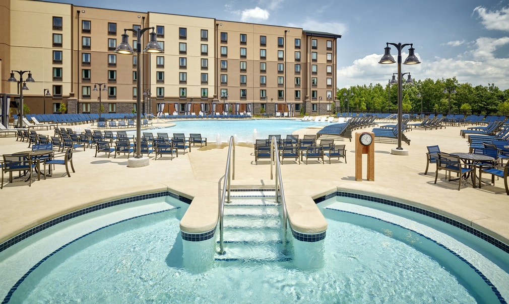 outdoor hot tub with a swimming pool in the background