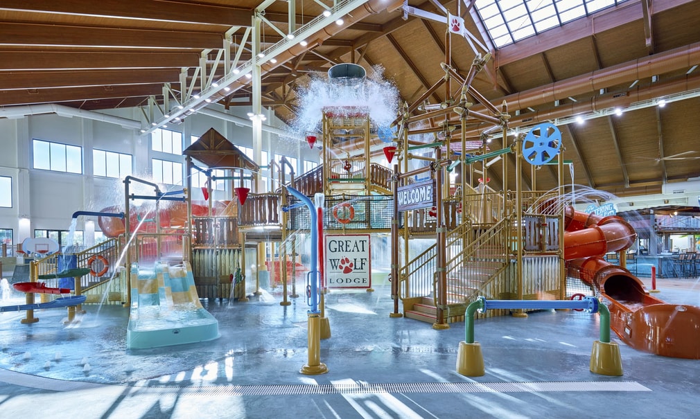 Water bucket splashes water over the top of the stairs and slides of indoor water park