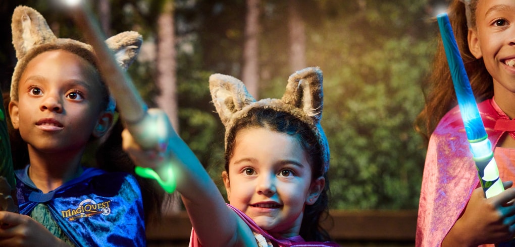 Three children wearing wolf ears holding magic wands.