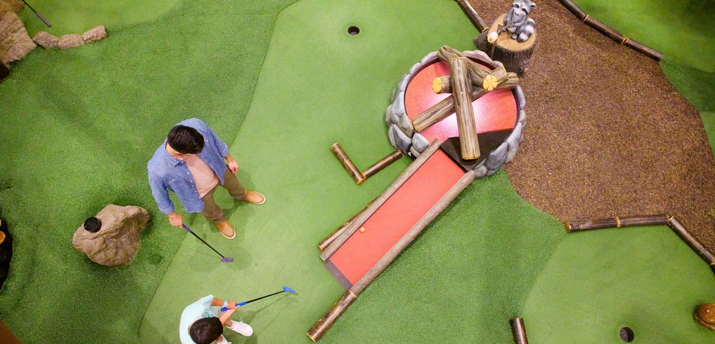 Overhead shot of a family playing mini golf