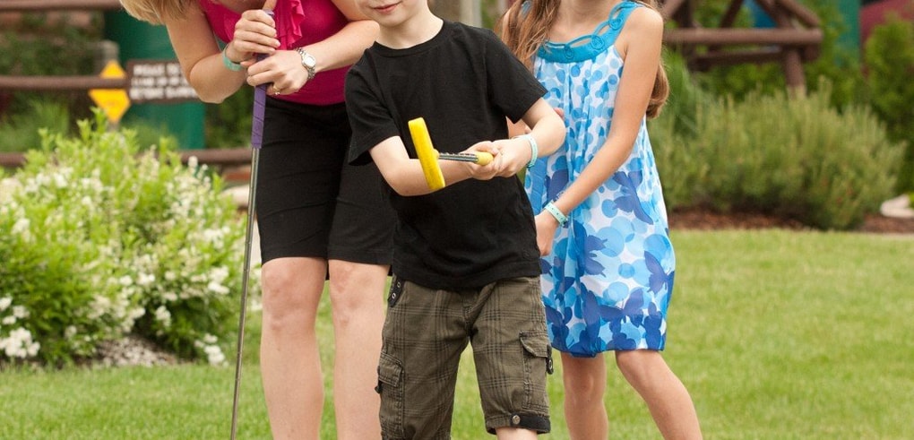A family plays a round of mini golf 