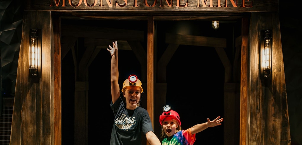 Two kids posing excitedly in front of Moonstone Mine