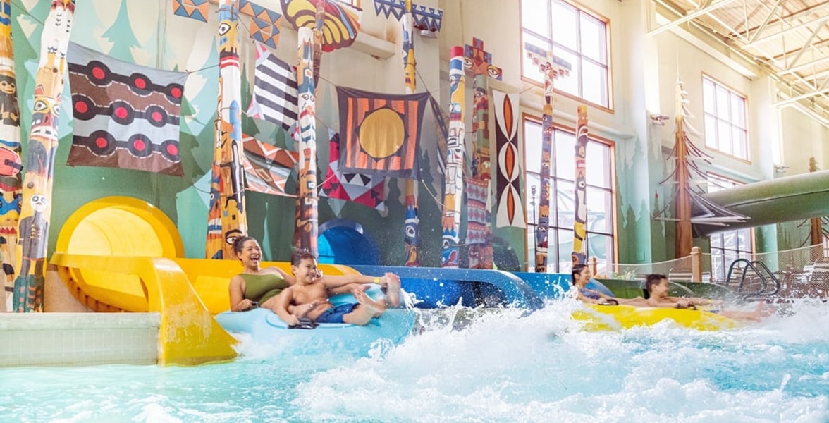 Family enjoying Bobcat Falls at Great Wolf Lodge indoor water park and resort.