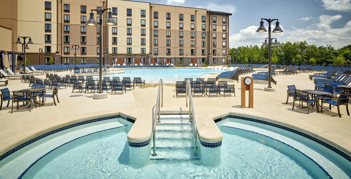 outdoor hot tub with a swimming pool in the background