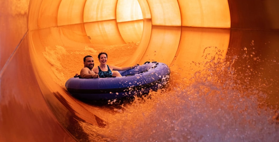A family enjoys rafting together at Great Wolf Lodge indoor water park and resort.