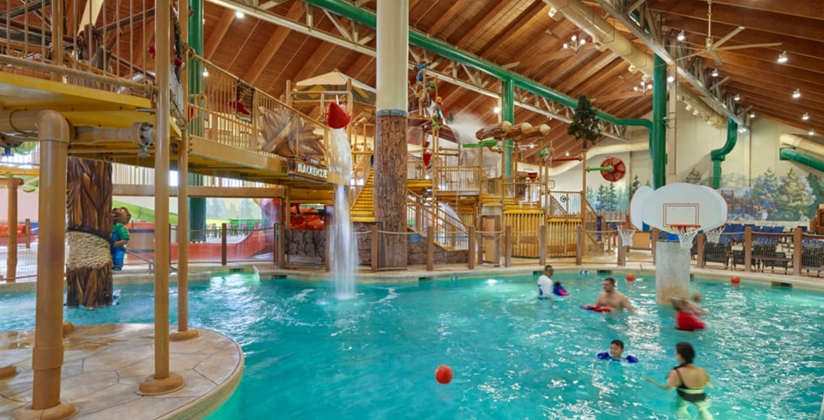 family playing basketball in indoor pool 