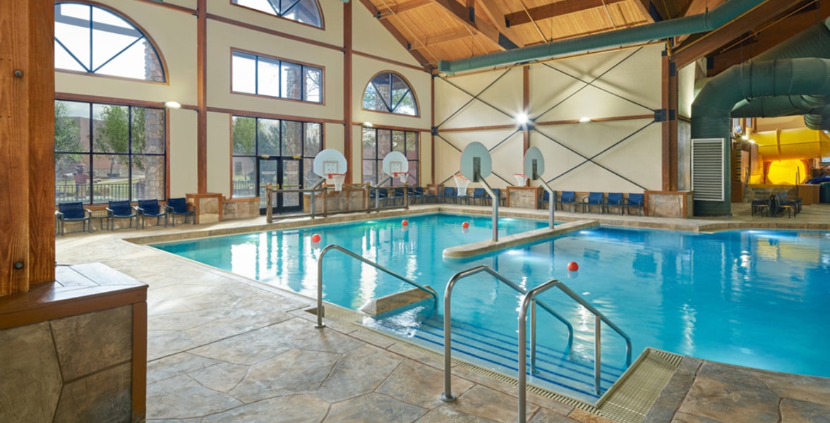 family playing basketball in indoor pool 
