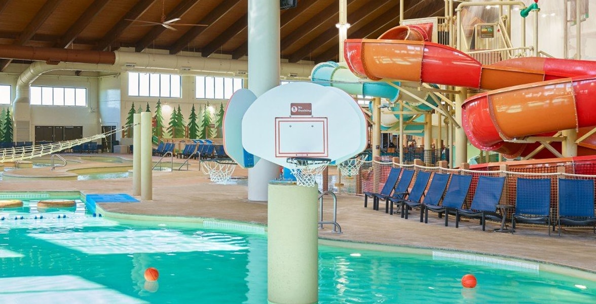 family playing basketball in indoor pool 