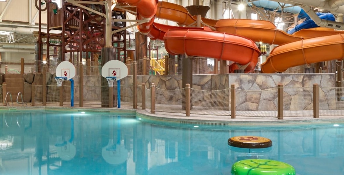 family playing basketball in indoor pool 