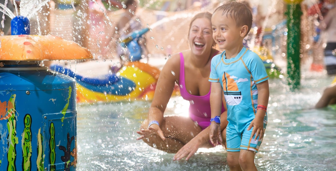 mother and child playing in a kiddie pool
