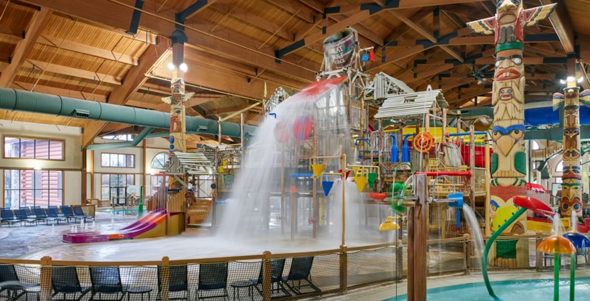 A wide shot of the  water treehouse as water splashes down from a bucket above the jungle gym