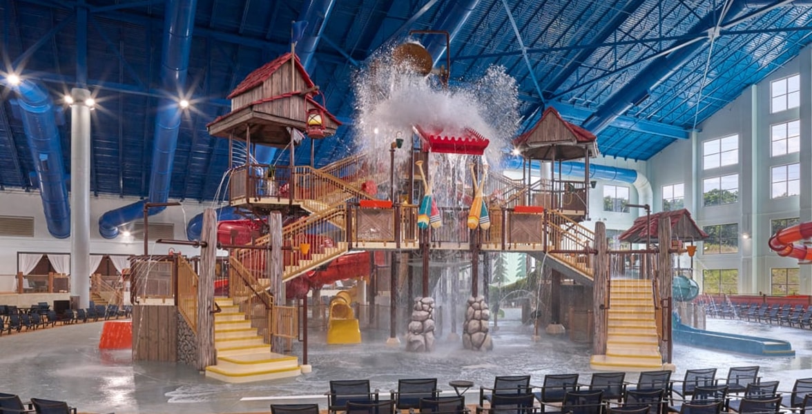 A wide shot of the  water treehouse as water splashes down from a bucket above the jungle gym