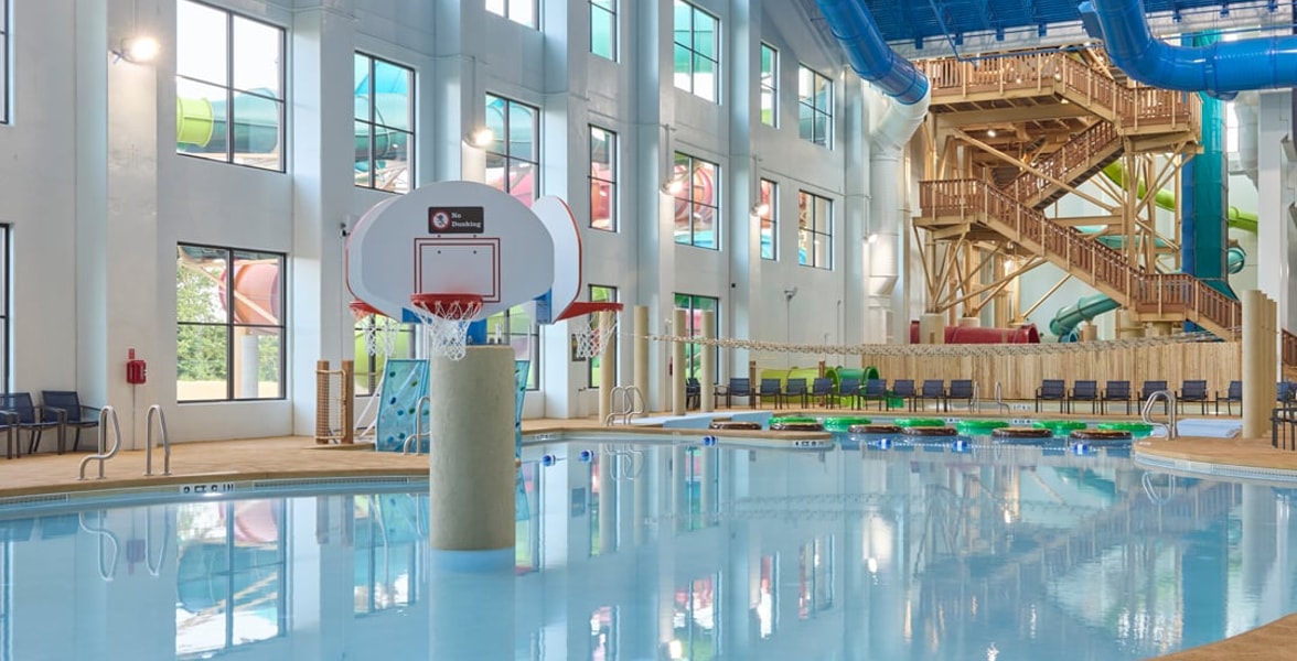 family playing basketball in indoor pool 
