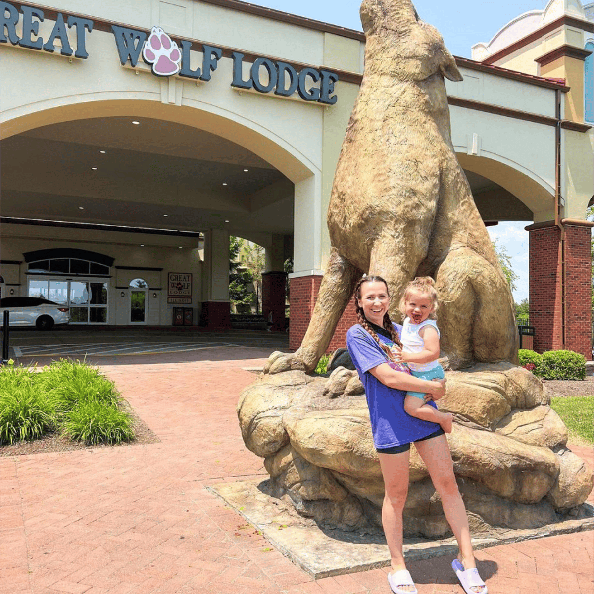 three kids taking a pause in front of the great wolf lodge sign