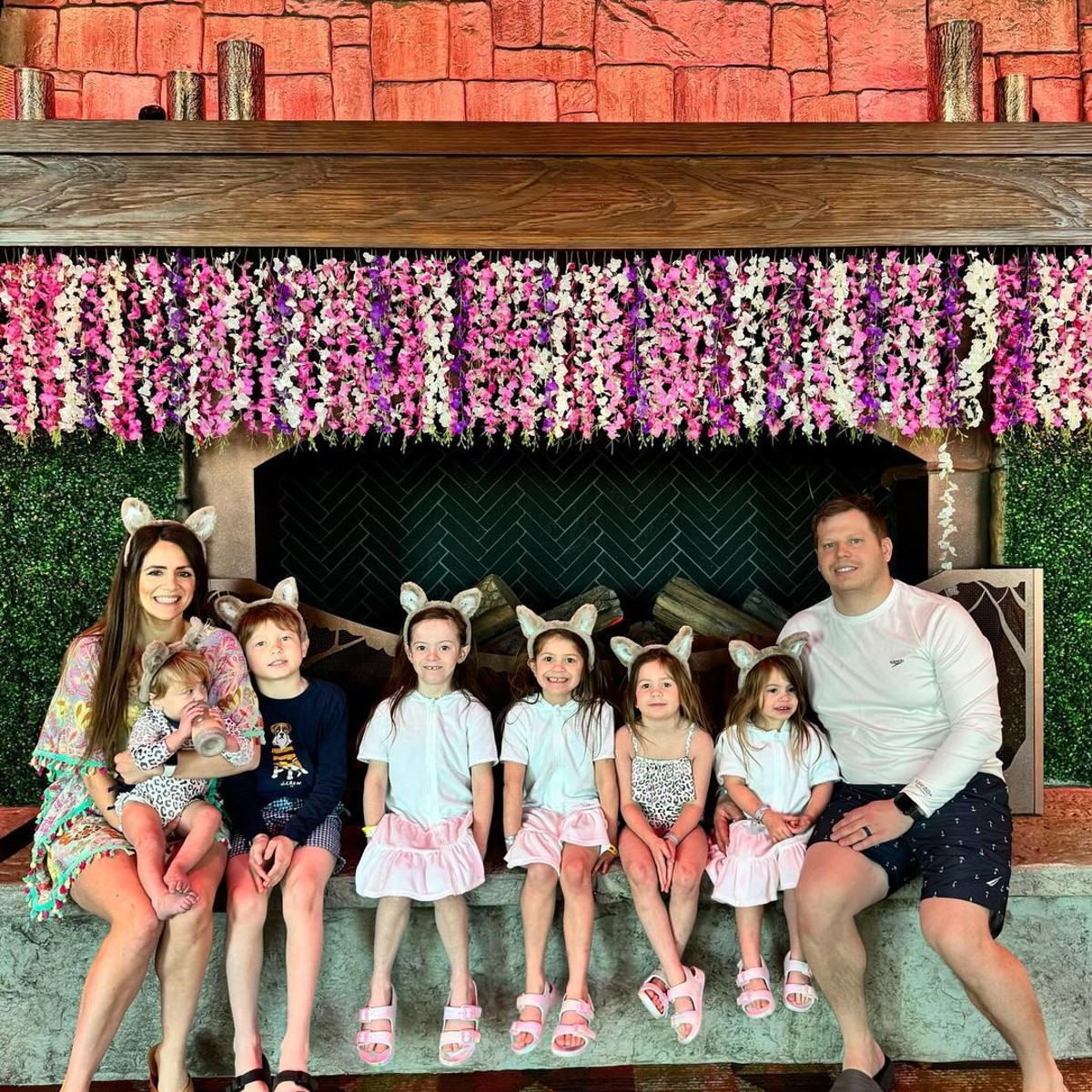 family pausing in front of the grand lobby fireplace