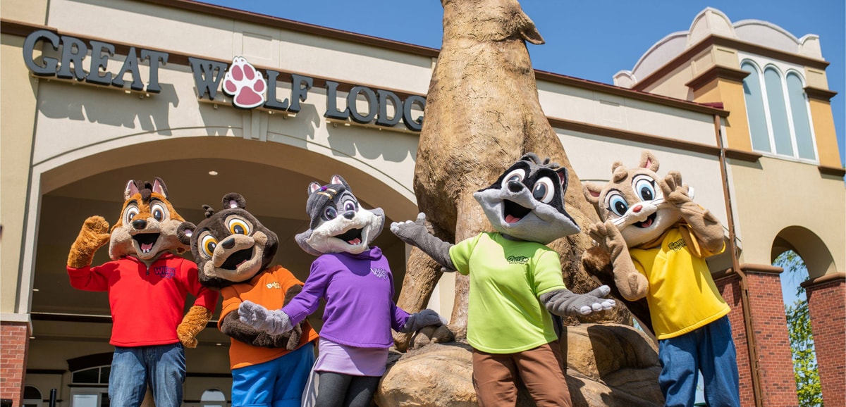 Great Wolf Lodge mascots posing in front of entrance statue