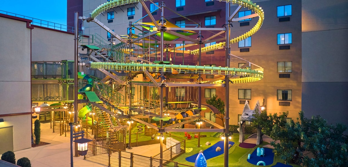 Smiling girl in harness on a rope bridge