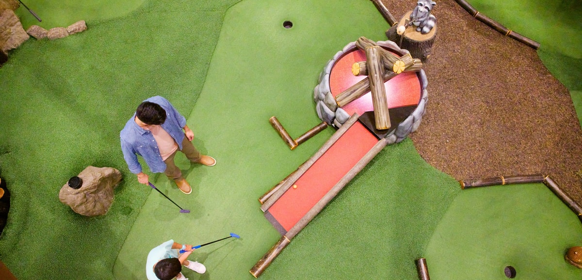 Overhead shot of a family playing mini golf
