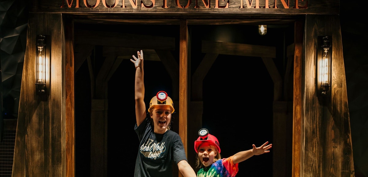Two kids posing excitedly in front of Moonstone Mine