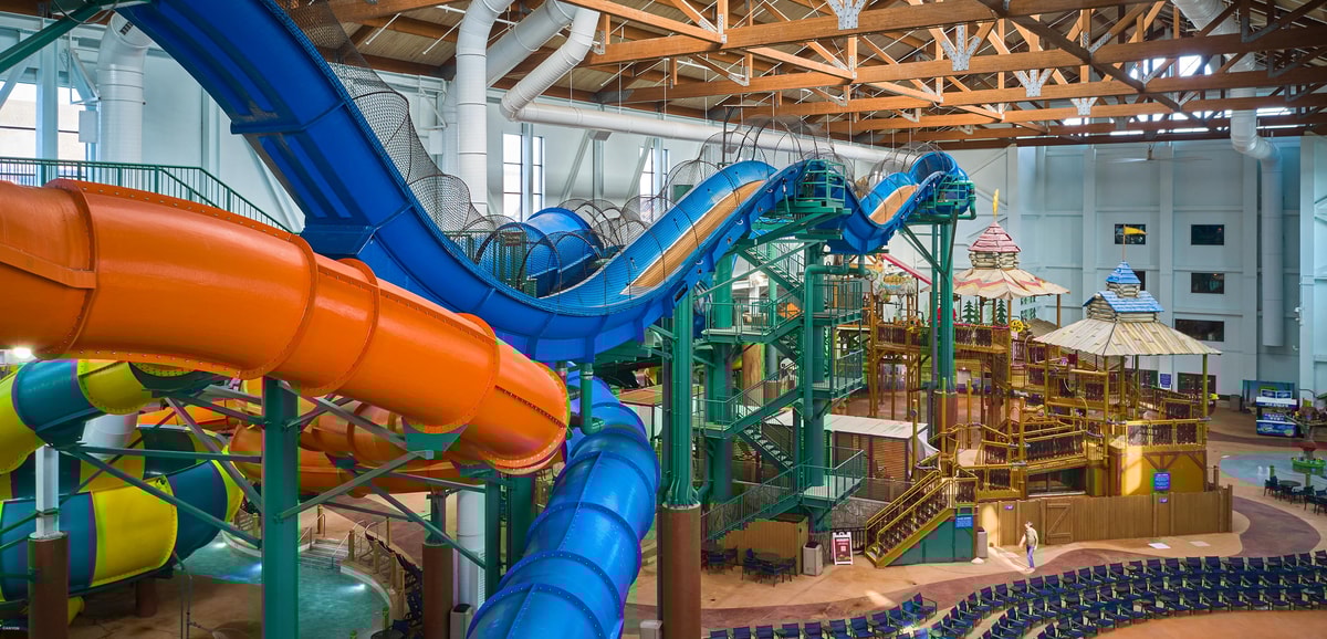 view of the indoor water park with a yellow and blue slide 