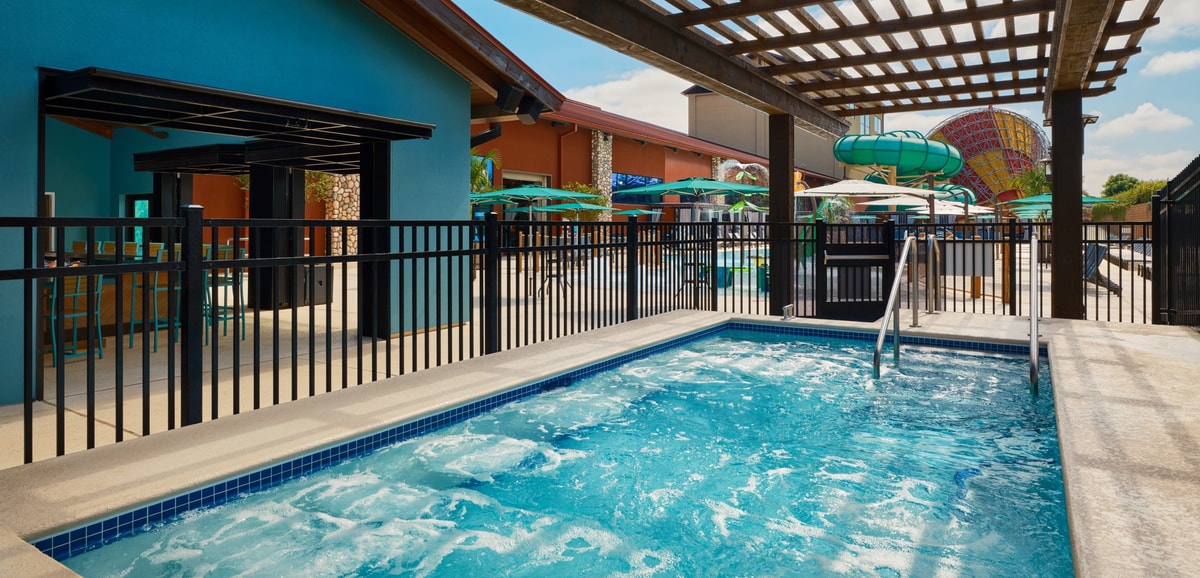 Two couples relax in an indoor hot tub