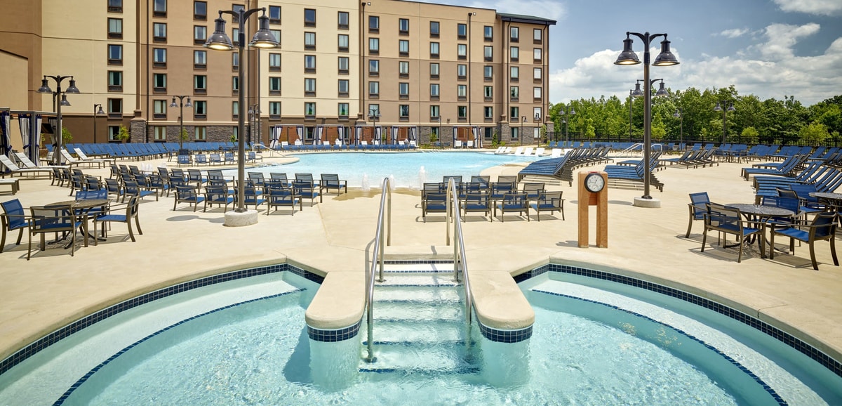outdoor hot tub with a swimming pool in the background