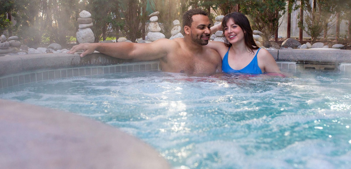 A couple relaxes in an outdoor hot tub