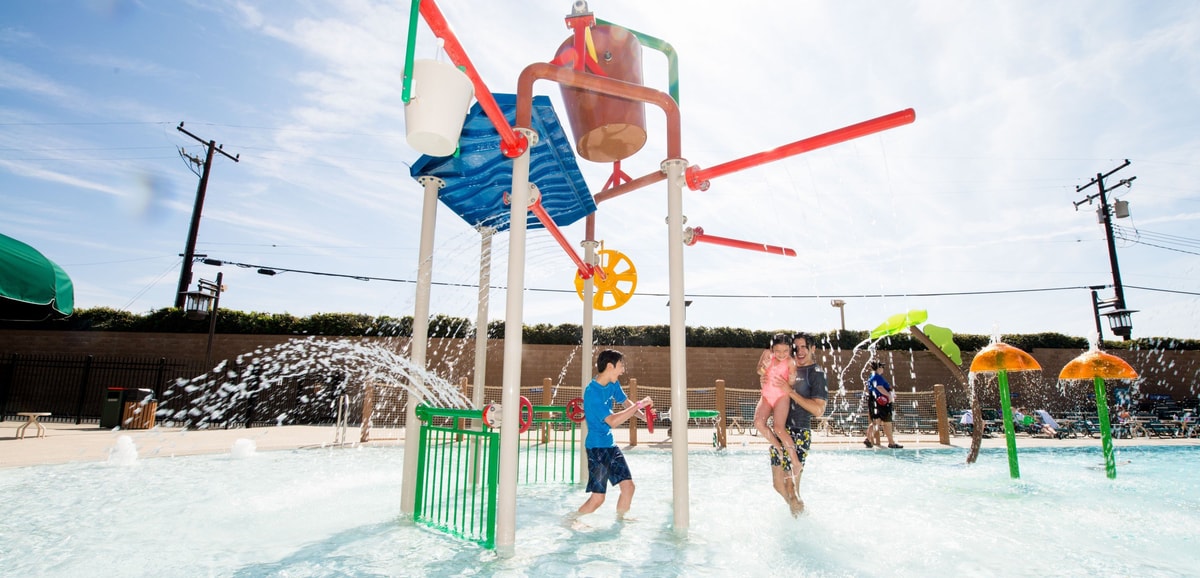 Kids play behind the outdoor water features 