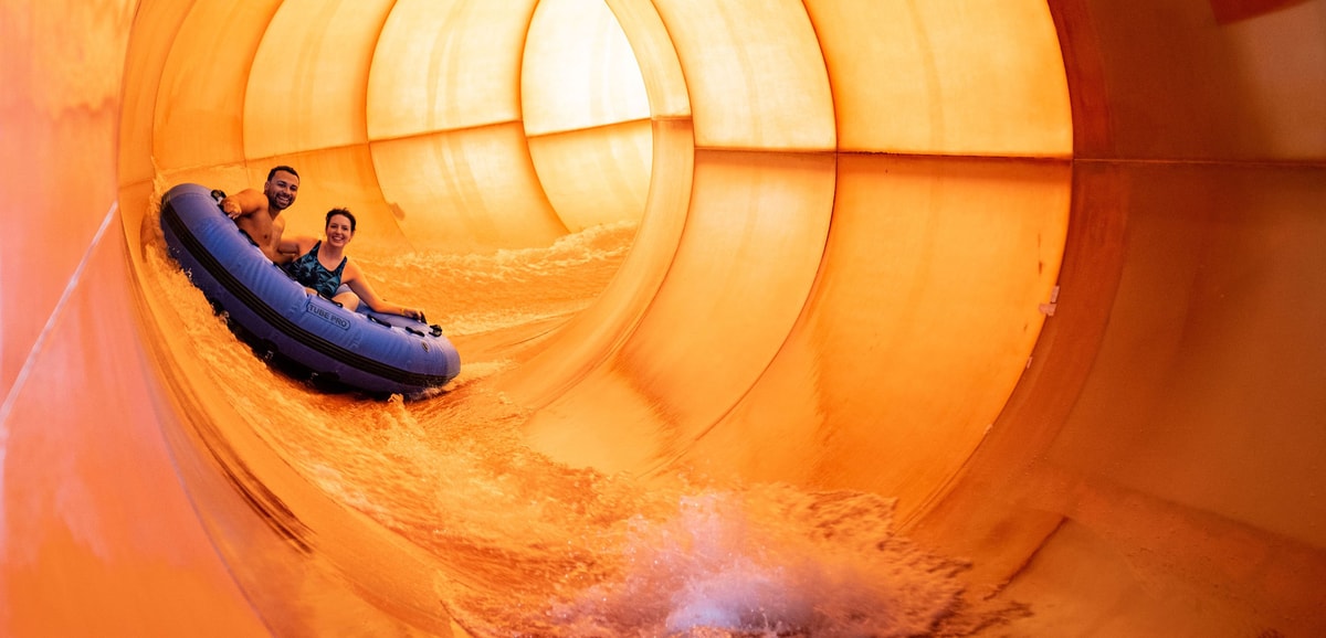 Couple on a blue raft going down a water slide