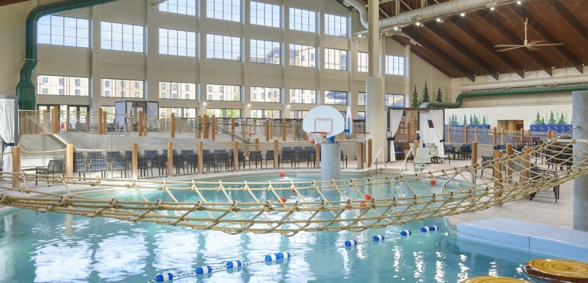 Indoor water park scene with a rope bridge