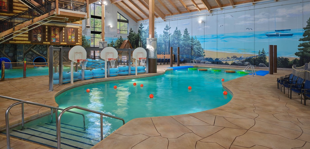family playing basketball in indoor pool 