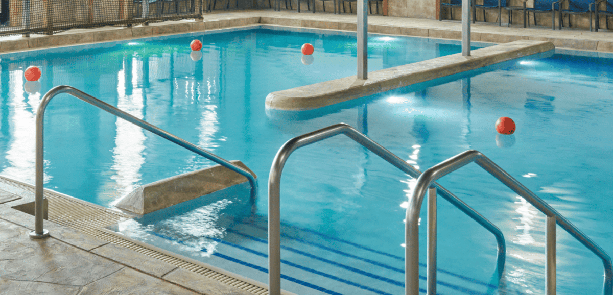  A spacious indoor pool featuring a large slide and multiple water slides for recreational enjoyment.