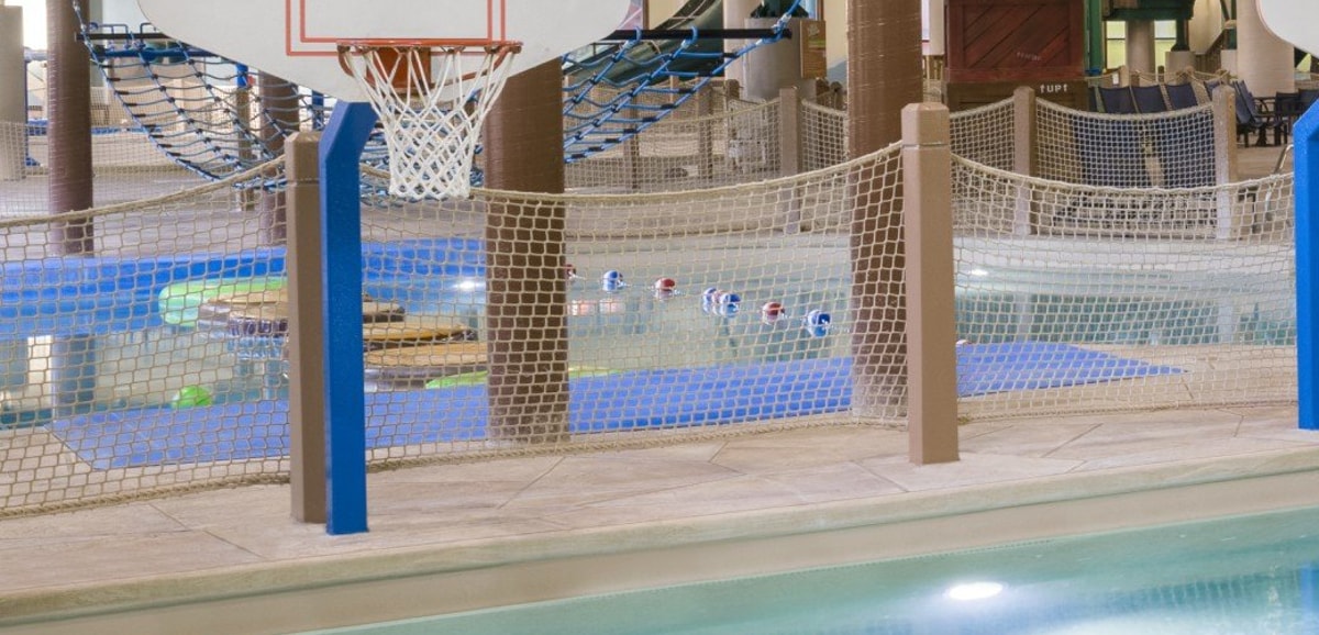 A vibrant water park featuring a basketball hoop and multiple water slides for fun and recreation.