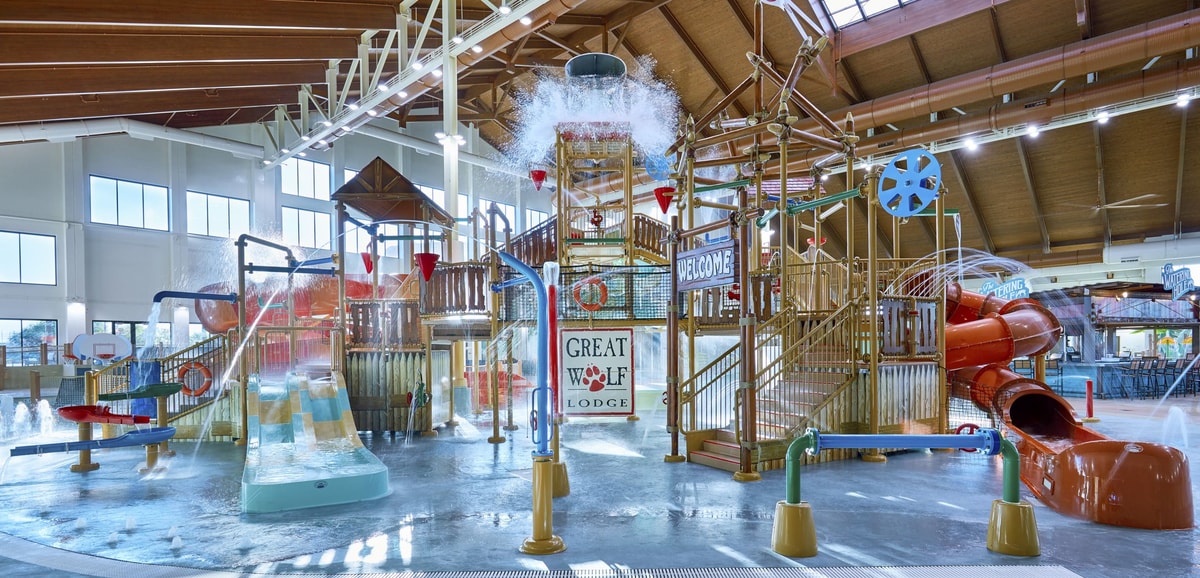 Water bucket splashes water over the top of the stairs and slides of indoor water park
