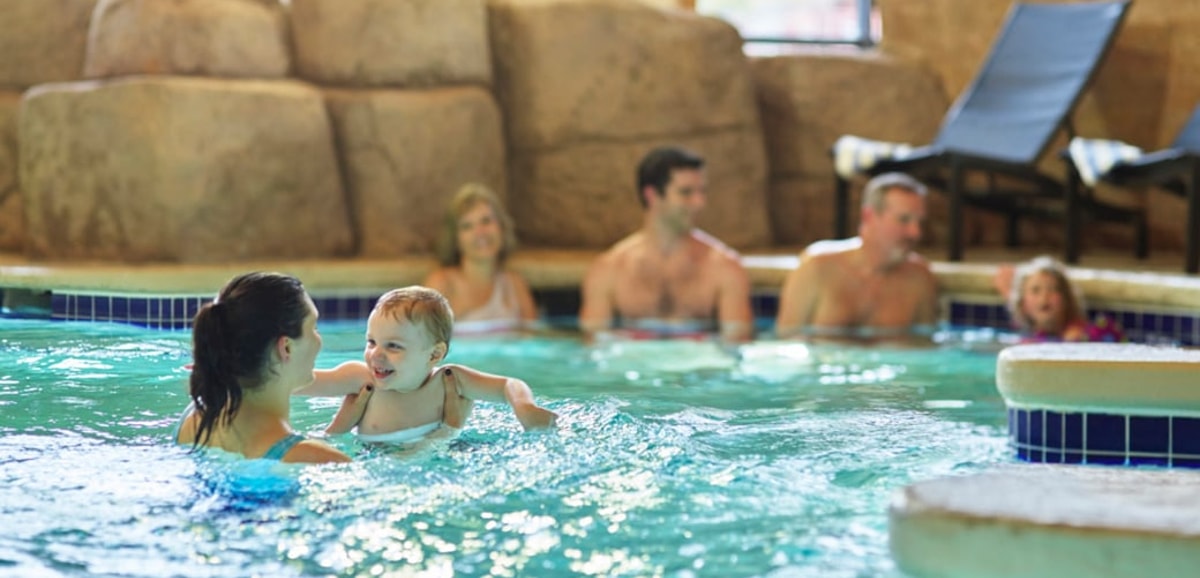 Mother holding baby in a pool 
