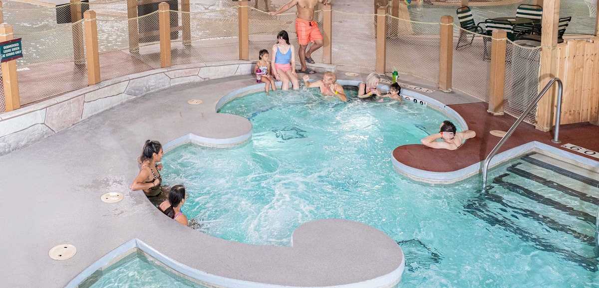 A family relaxes in an indoor hot tub