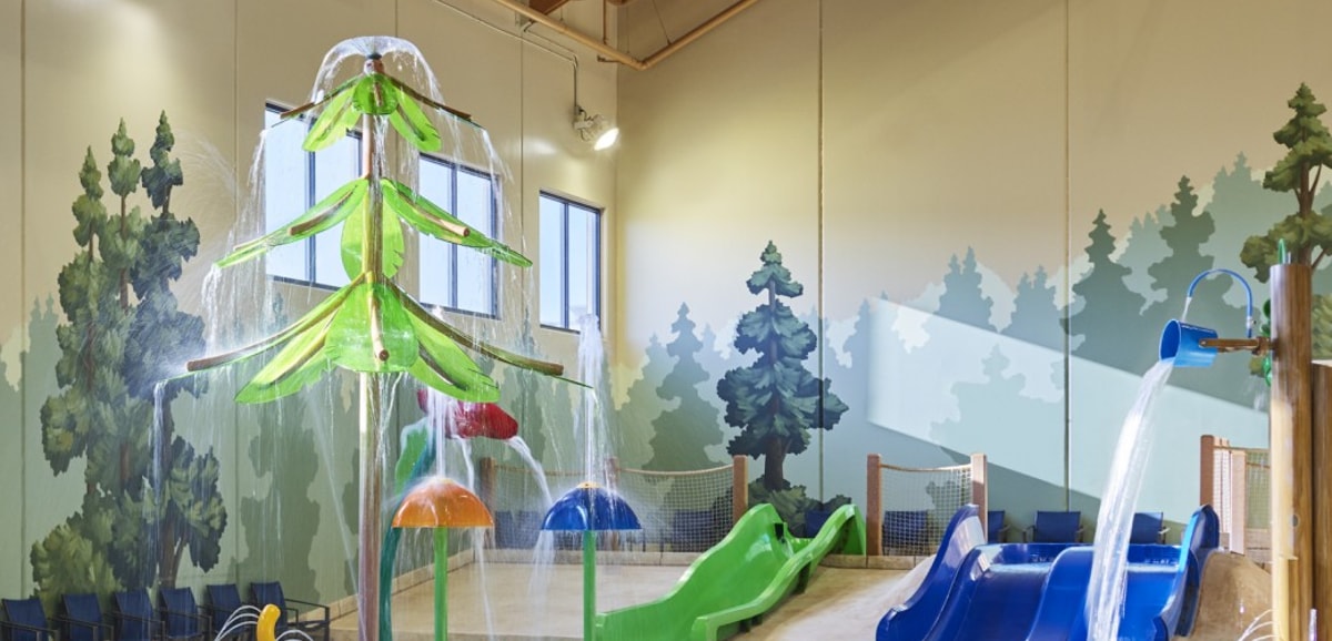 little boy about to go down a yellow kiddie slide