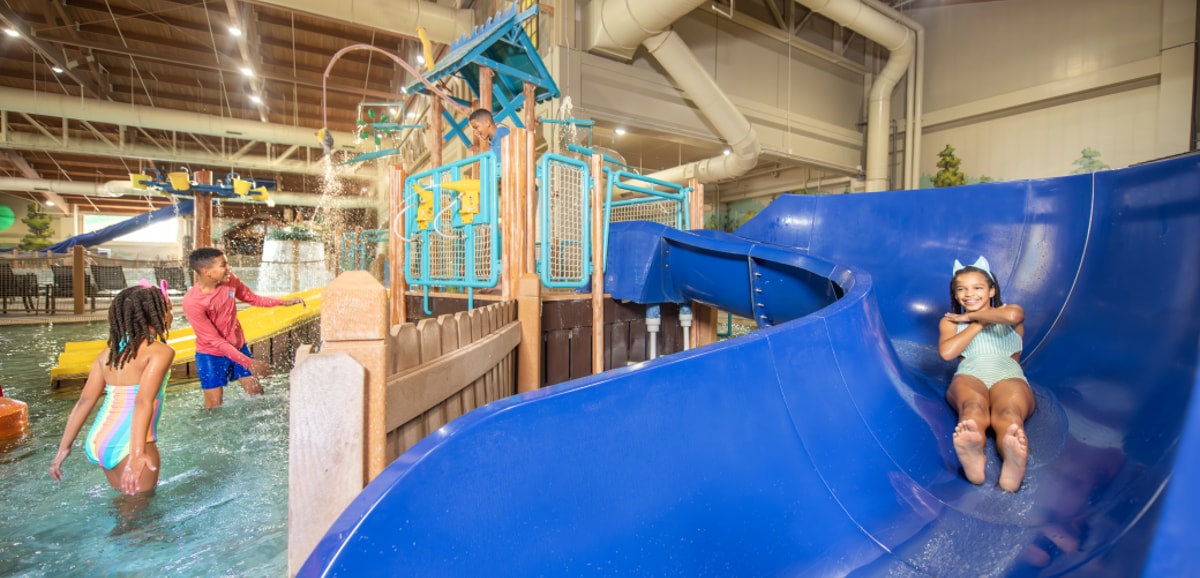 father looking upon his daughters going down the water slide