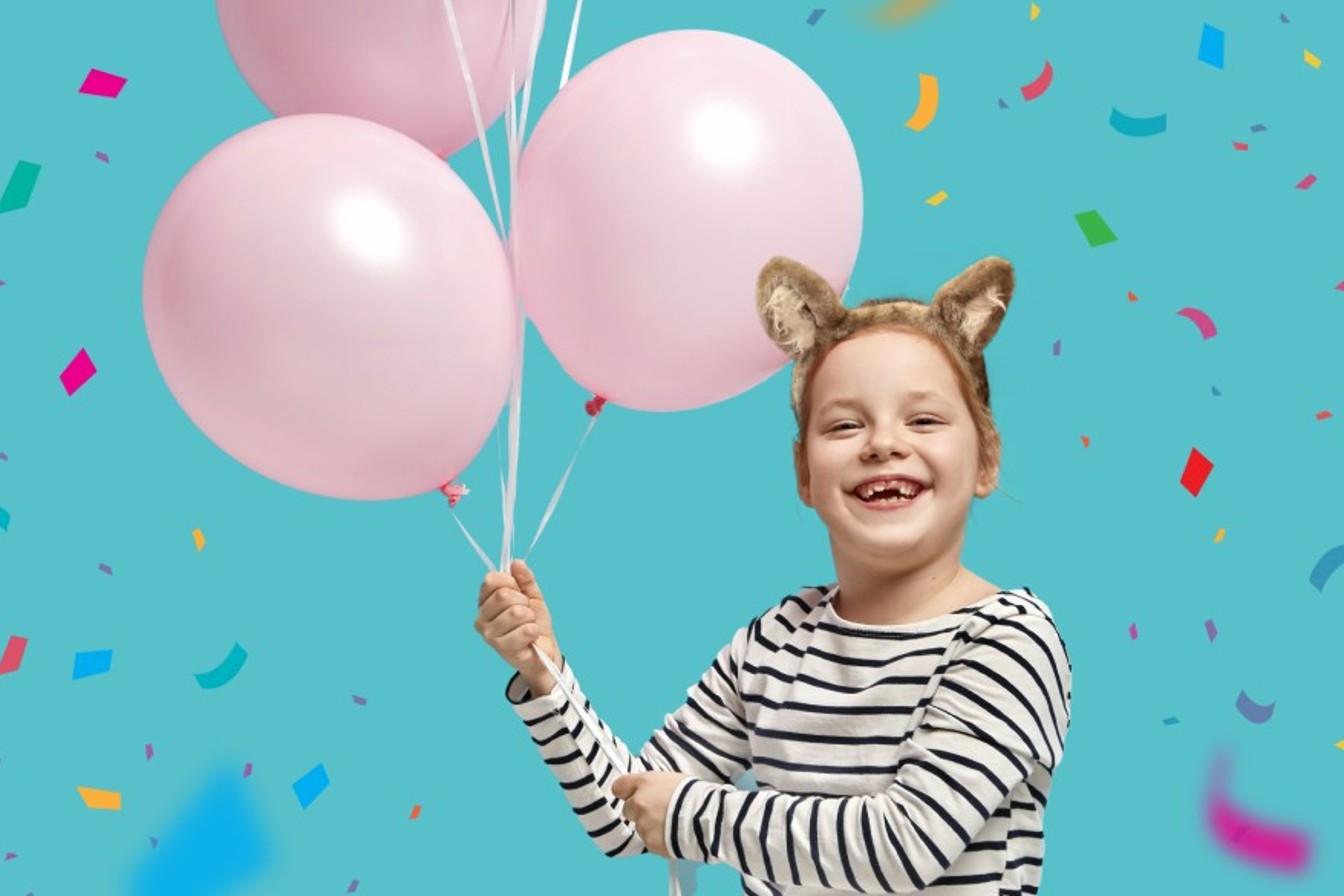 Girl with balloons at birthday party at Great Wolf Lodge