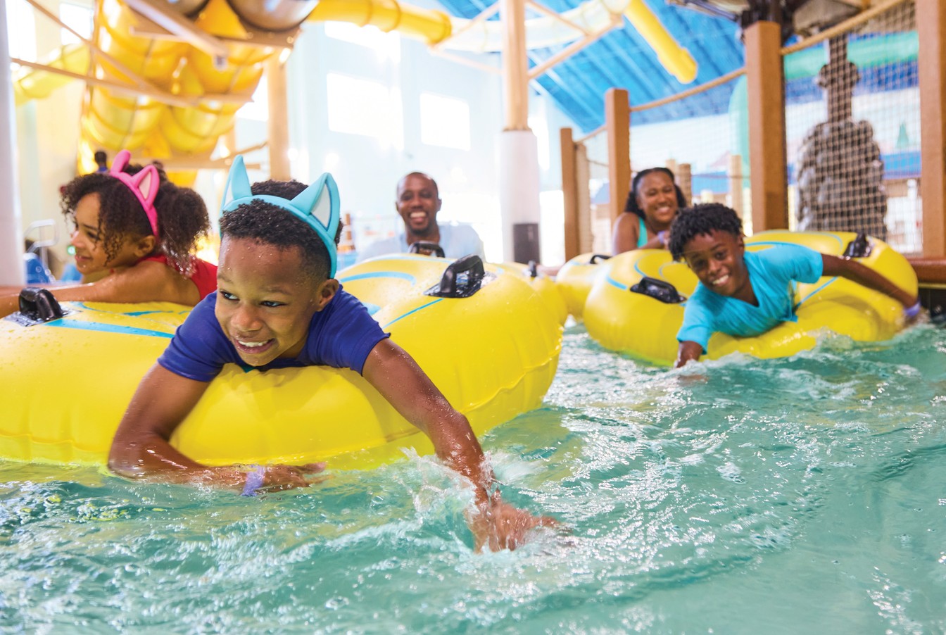 family floating in lazy river water ride using tubes