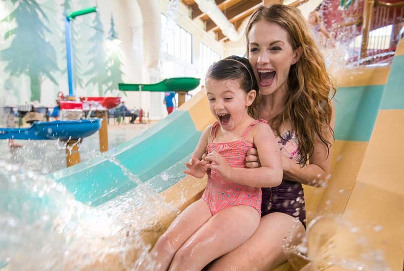 A kid and her mother enjoying a water slide 
