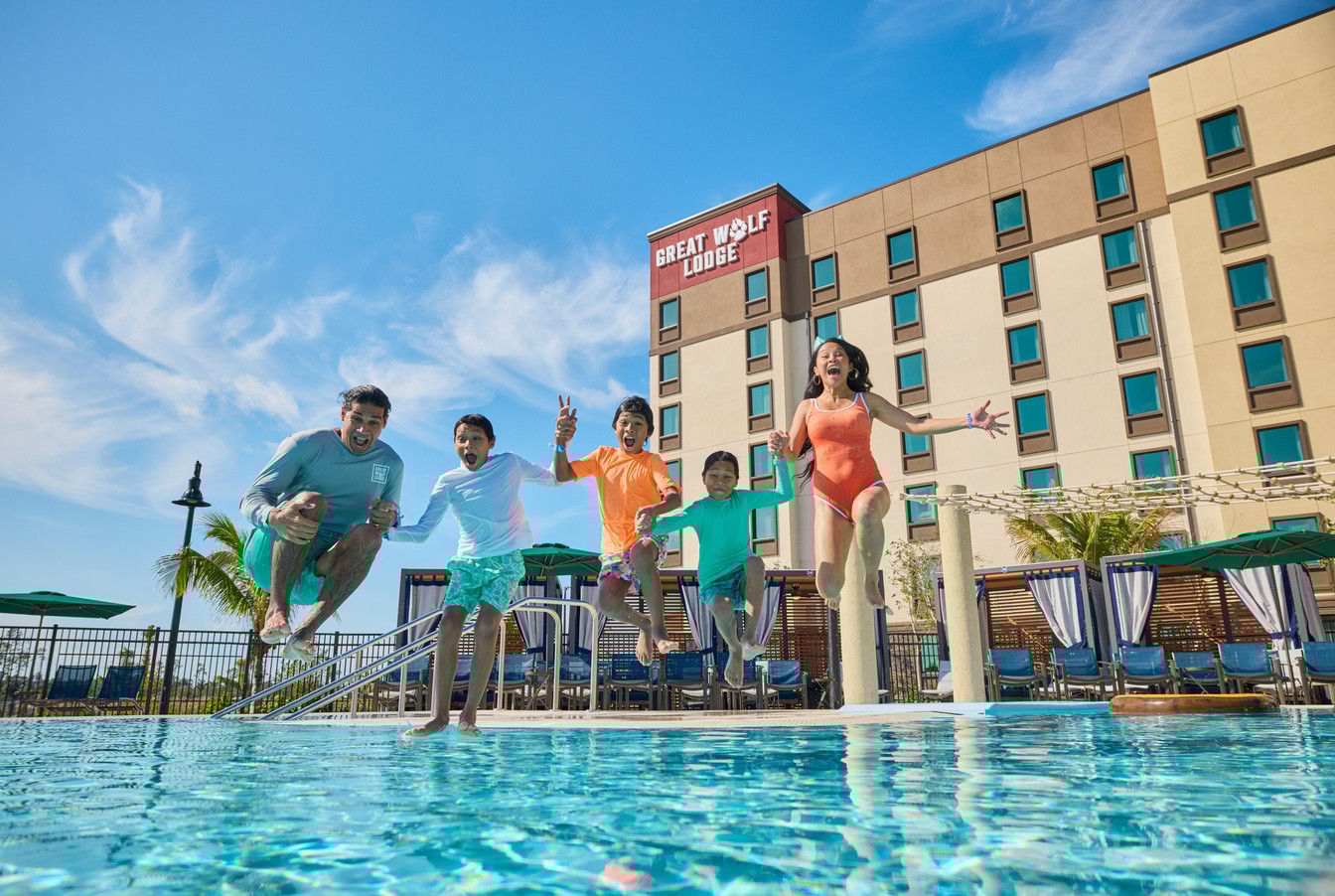 kids jumps into the pool as parents watch excitedly