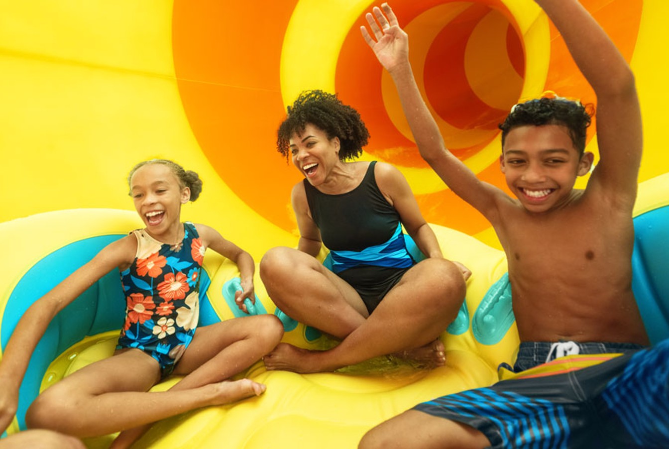 family floating on tube sliding down a waterslide