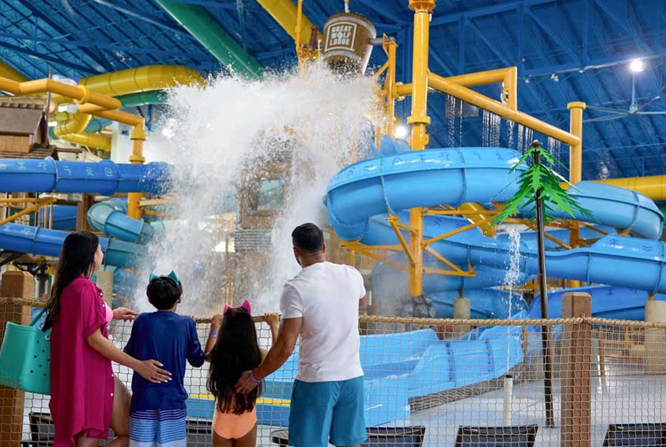 family standing in front of water bucket splashing water
