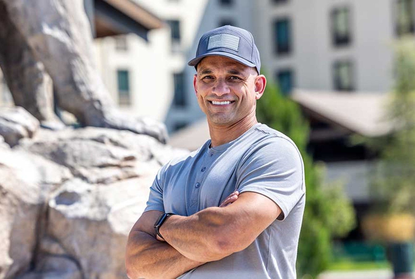 man wearing a blue shirt in front of a Great Wolf lodge