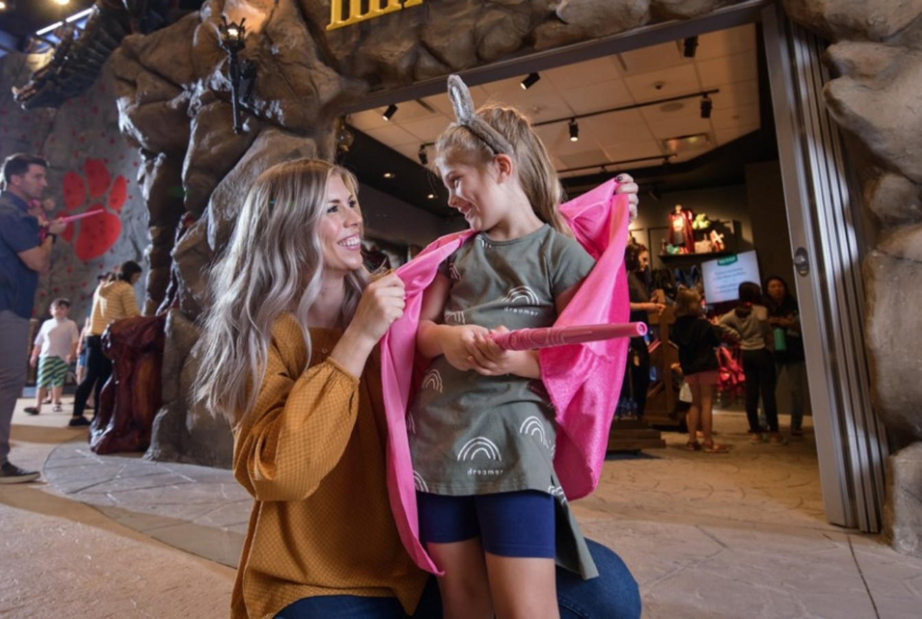 Two kids hold their wands playing MagiQuest