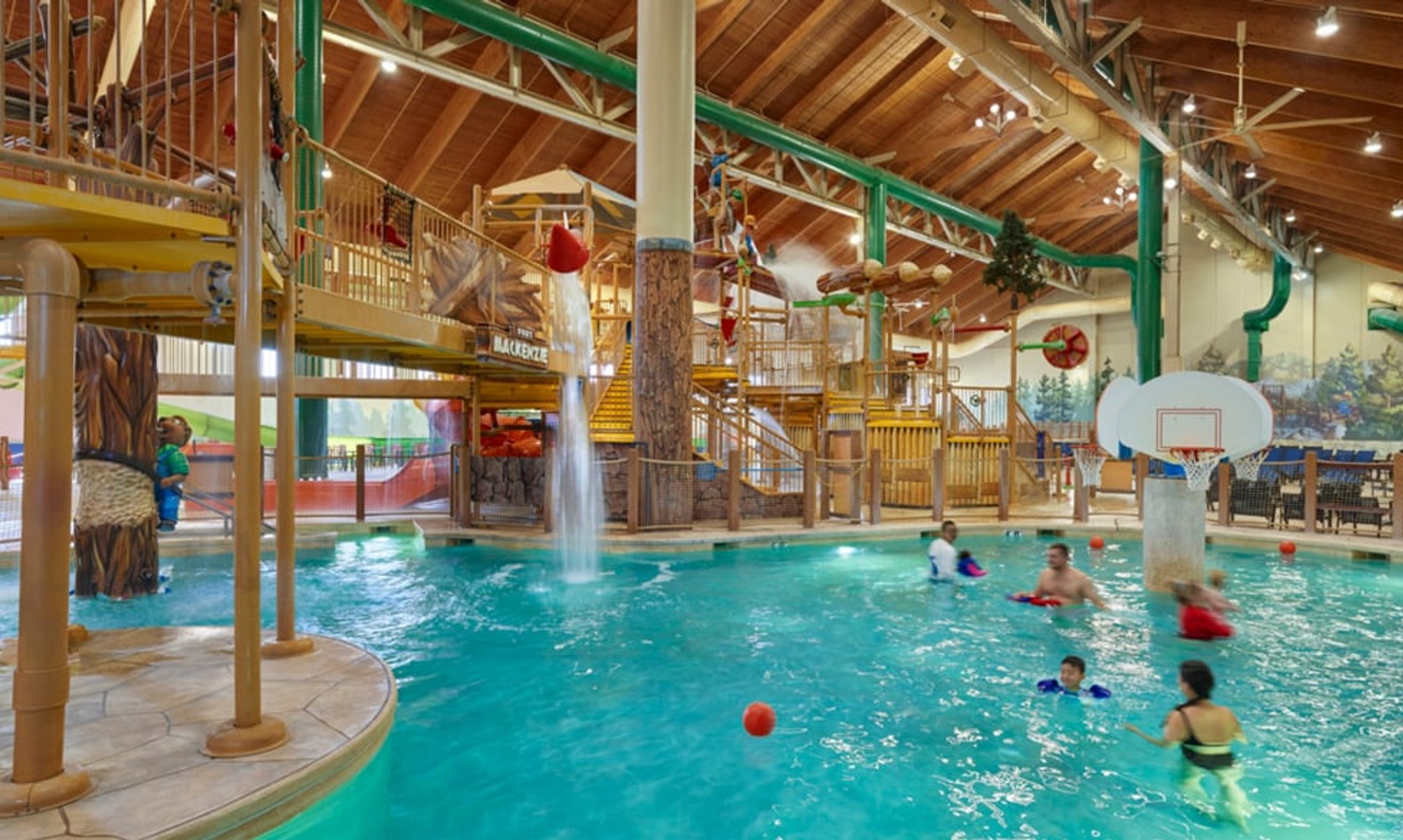 family playing basketball in indoor pool 
