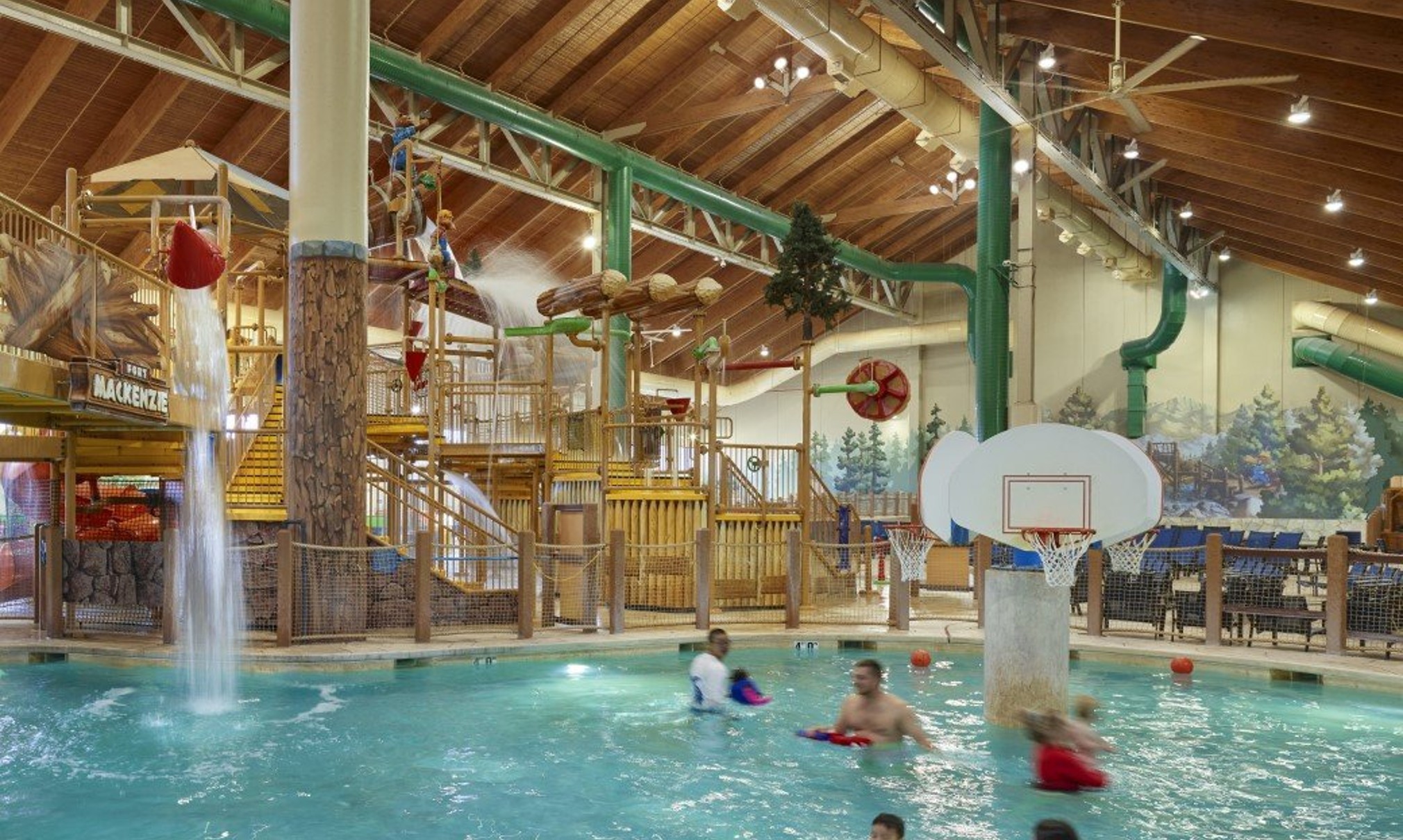family playing basketball in indoor pool