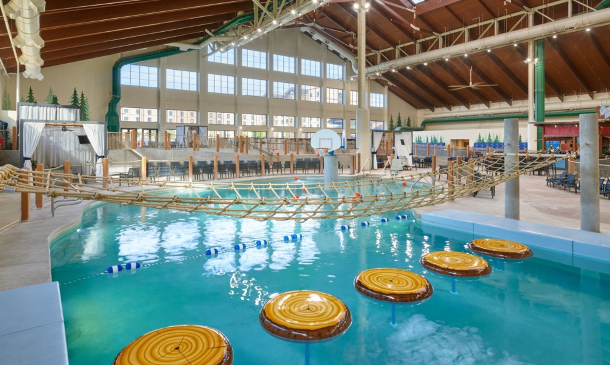 family playing basketball in indoor pool 