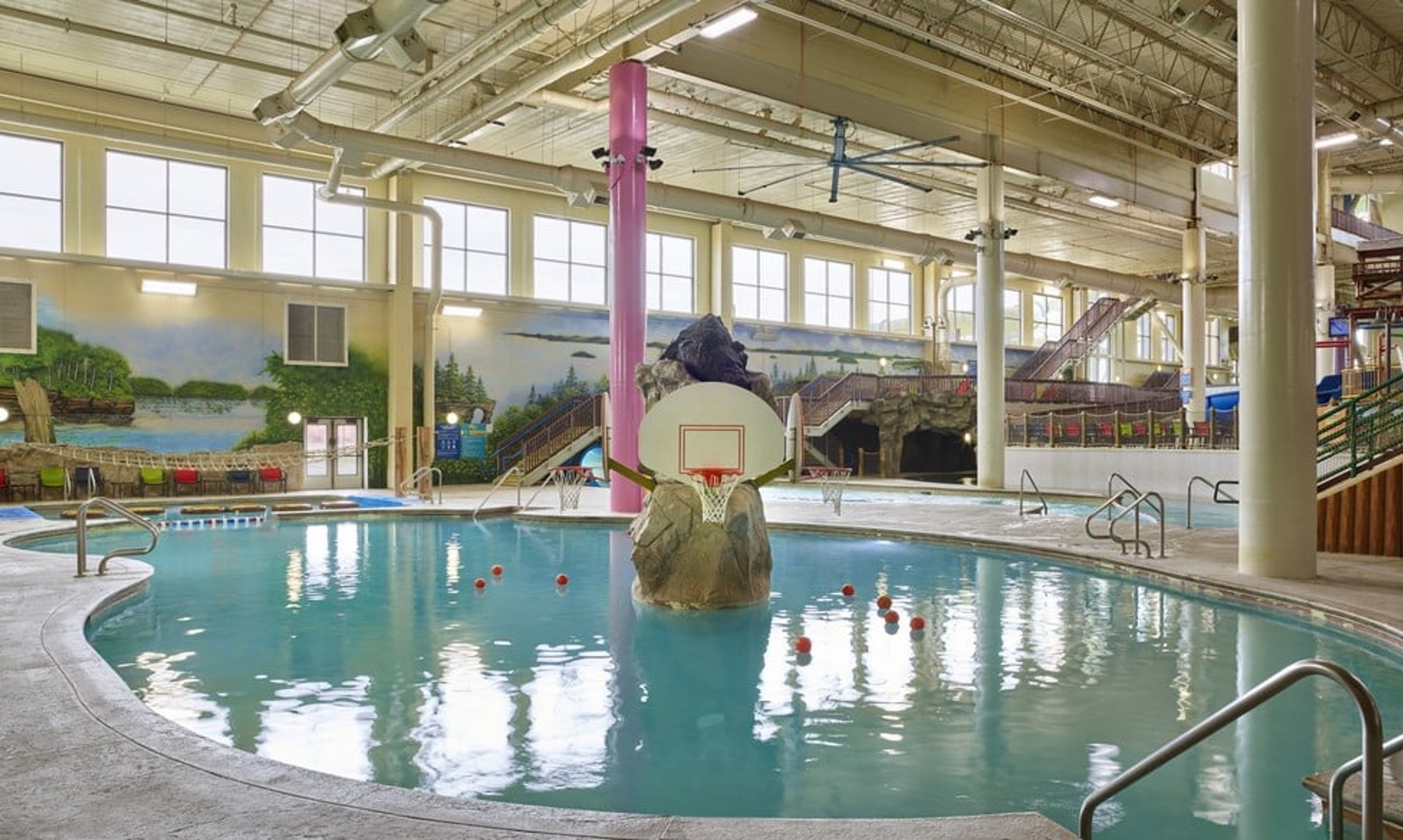 family playing basketball in indoor pool 